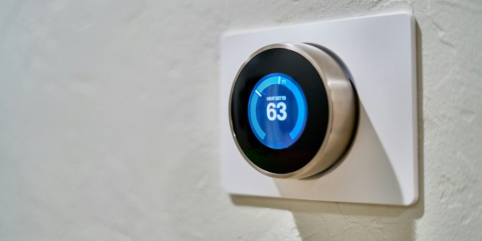 gray Nest thermostat displaying at 63